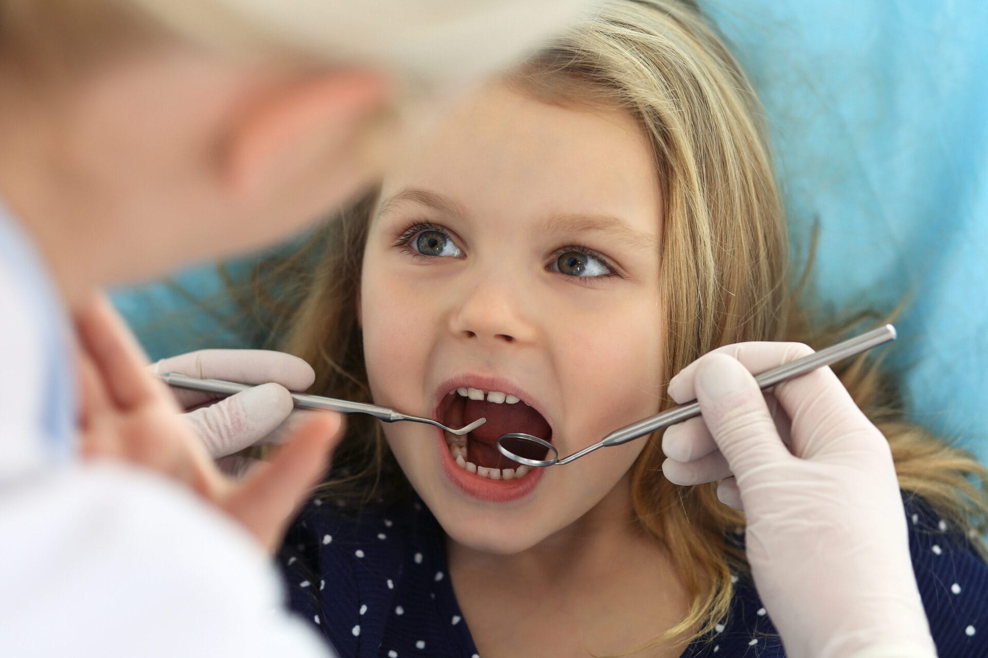 When to schedule your child's first dentist visit. Toddler getting teeth checked at San Antonio dentist.